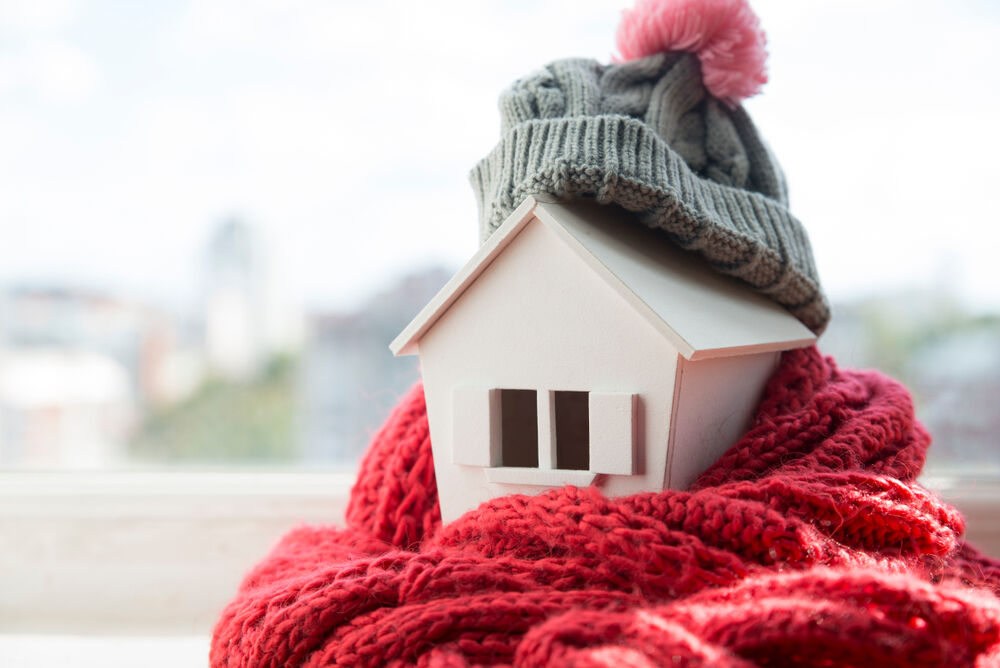 Small house wrapped in winter scarf and hat